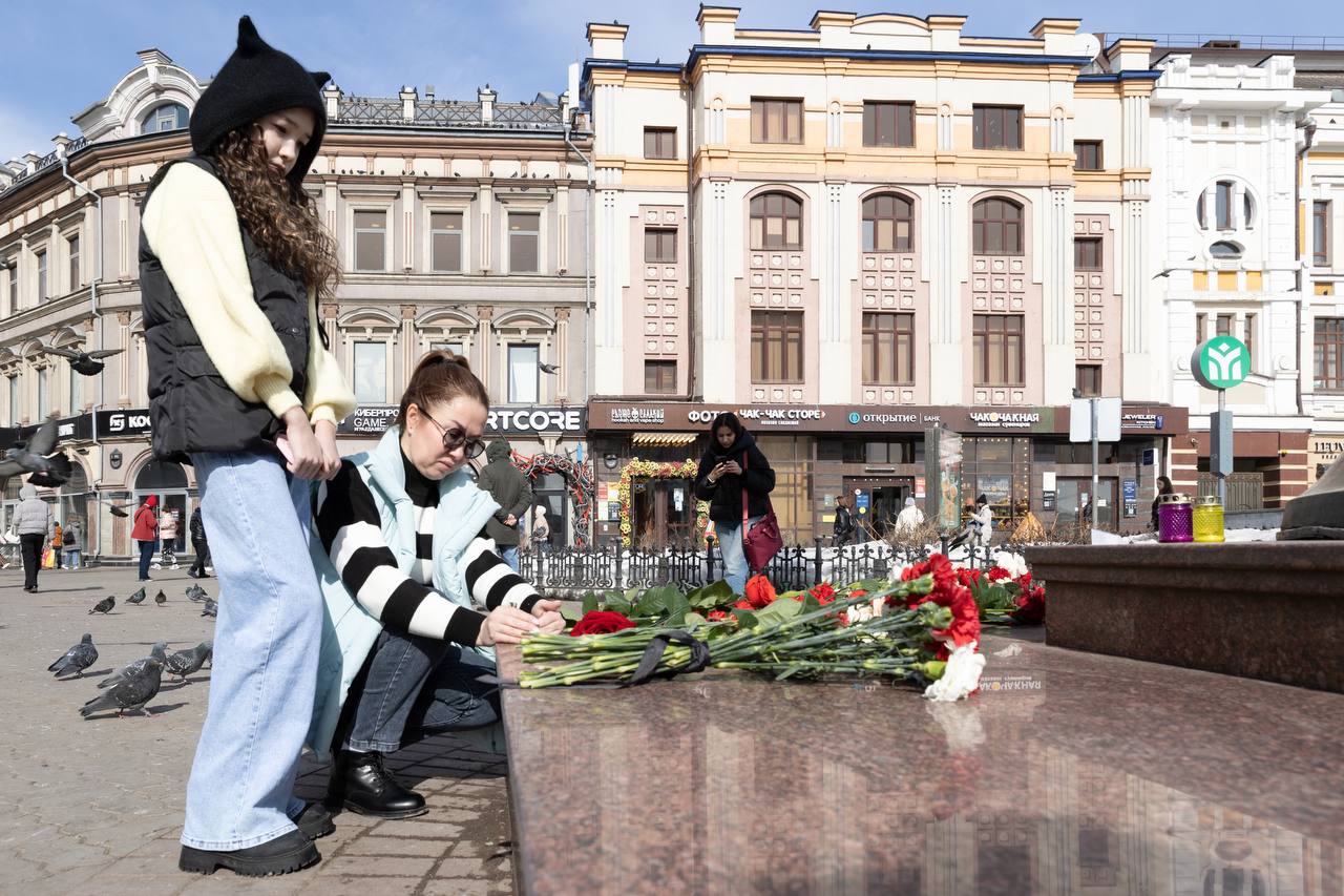 Казанцы приносят цветы к стихийному мемориалу у часов на Баумана